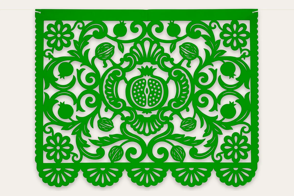 Papel picado barroco para la temporada de nogada en verde bandera: granada abierta con semillas caladas dentro de una cartela barroca, con hojas de acanto, nueces y rosetas de talavera